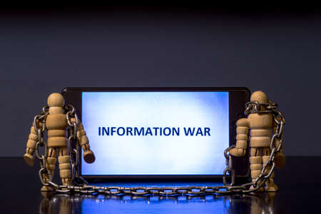 The written word information war on the screen of a mobile smartphone with two figures of people...