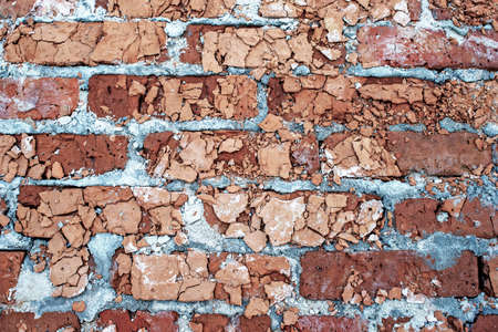 The remains of a concrete building. Part of the wall of red brick closeup lying in a pile of rubble.の写真素材