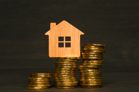Bamboo house with yellow coins in the form of a close-up graph on a dark background. The concept of the growth of utility payments of the population due to the increase in the cost of energy carriersの写真素材