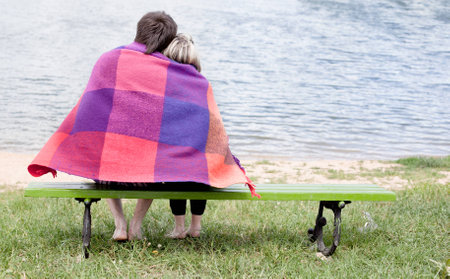 Loving couple looking at the water in the park.の写真素材