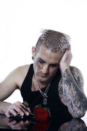 studio shot of a sad   man  with tatoos and piercingの写真素材