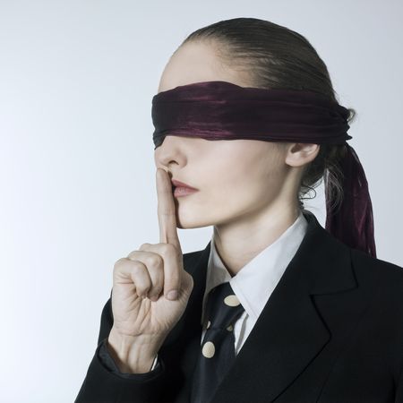 studio shot portrait of a beautiful young blindfold woman in a costume suit の写真素材