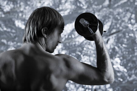 studio portrait of handsome blond man torso naked doing workoutの写真素材