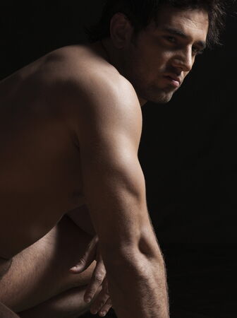 Close-up of a naked young man looking agressiveの写真素材
