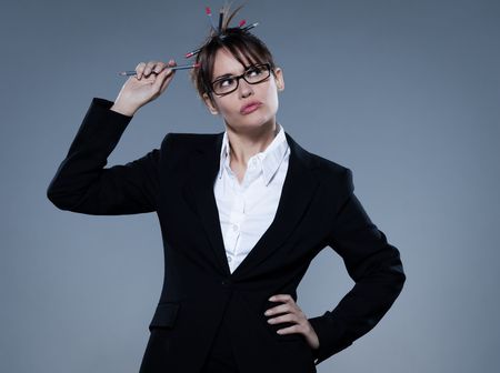 beautiful business woman on isolated bacground thinking cheewing her pencilの写真素材
