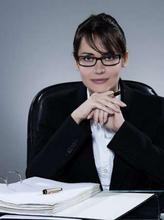 beautiful cheerful caucasian  business woman portrait sitting at desk on isolated backgroundの写真素材