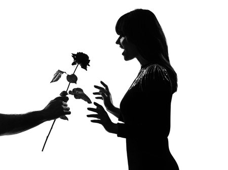 man hand offering a flower rose stylish sexy silhouette caucasian beautiful woman on studio isolated white backgroundの写真素材