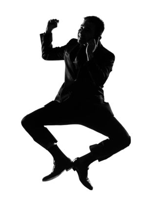 silhouette caucasian business man  expressing winning jumping on the phonebehavior full length on studio isolated white backgroundの写真素材
