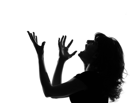 portrait silhouette in shadow of a young woman screaming anger  in studio on white background isolatedの写真素材