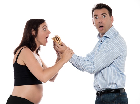 couple expecting baby hungry woman eat hamburger isolated studio on white backgroundの写真素材