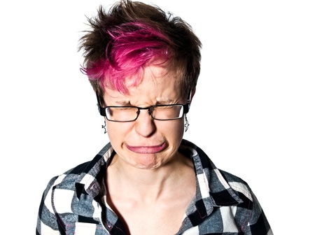 Close-up of a trendy young expressive woman crying in studio on white isolated background