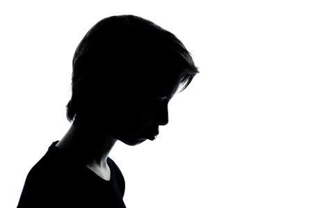 one caucasian young teenager silhouette boy or girl portrait moody pouting sad in studio cut out isolated on white backgroundの写真素材
