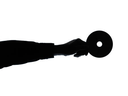 one caucasian business man hand holding compact dvd disk silhouette in studio isolated on white backgroundの写真素材