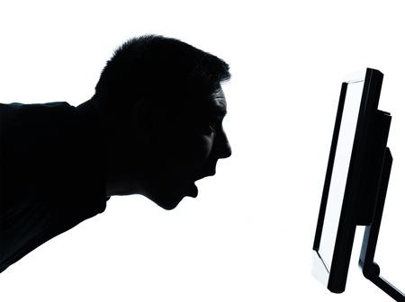 one caucasian business man face silhouette with computer screen display surprised portrait in studio isolated on white backgroundの写真素材