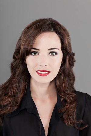 Closeup portrait of a beautiful brunette woman smiling isolated on gray backgroundの写真素材