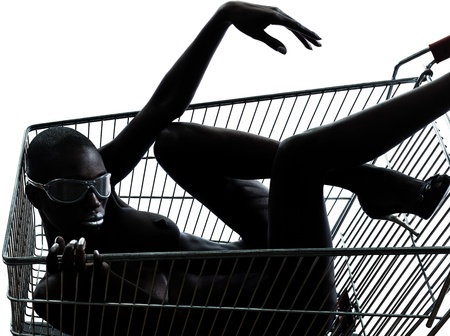 one beautiful black african naked woman sitting inside in a caddy shopping cart in studio isolated on white backgroundの写真素材
