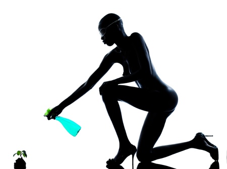 one beautiful black african naked woman protecting nature in studio isolated on white backgroundの写真素材