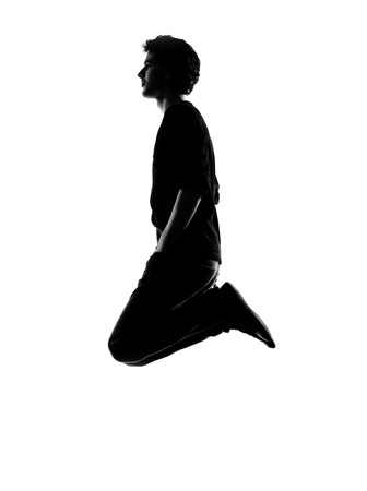 young man funny jumping silhouette in studio isolated on white backgroundの写真素材