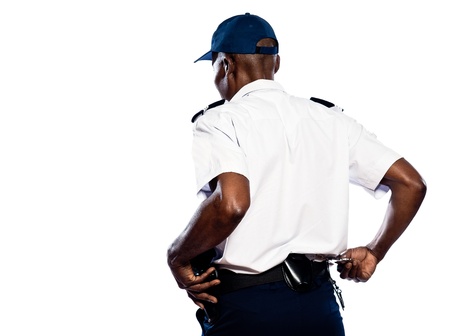 Rear view of afro American police officer pulling out handcuffs in studio on white isolated backgroundの写真素材