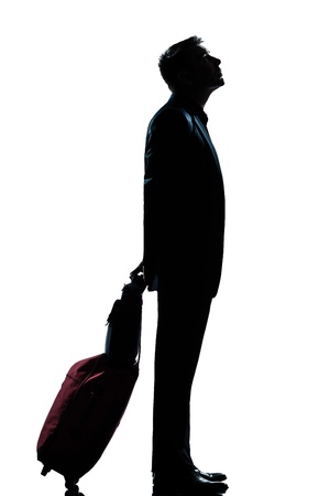 one caucasian man business traveler waiting looking up full length silhouette in studio isolated white backgroundの写真素材