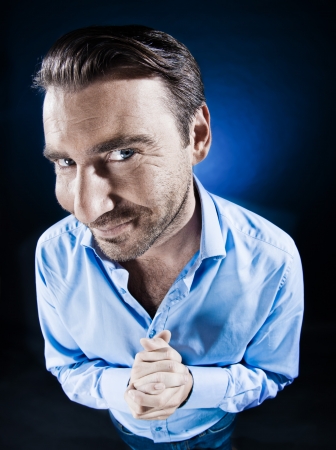 caucasian man beg malicious smile unshaven portrait isolated studio on black backgroundの写真素材