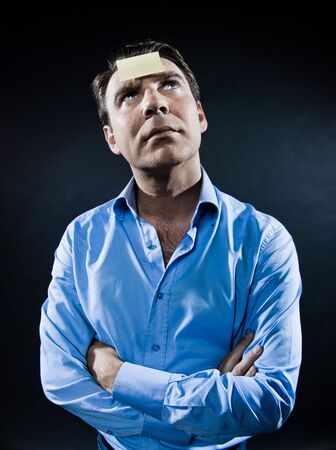 caucasian man looking up pensive portrait isolated studio on black backgroundの写真素材