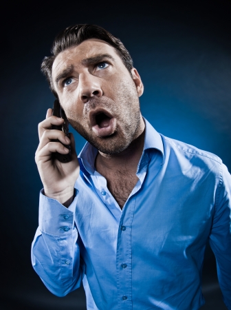 caucasian man unshaven screaming at phone angry portrait isolated studio on black backgroundの写真素材