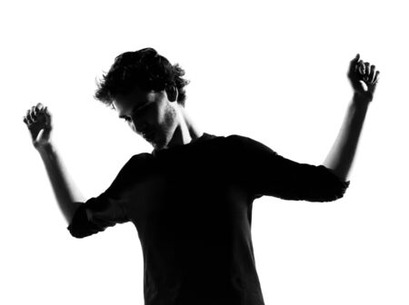 young man dancing happy silhouette in studio isolated on white backgroundの写真素材