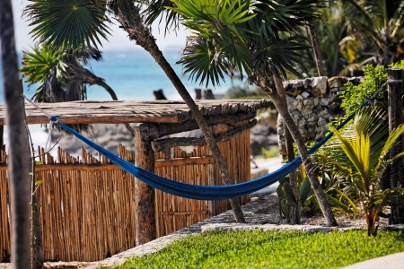 terrace of a cabana with a hamac and a view of the beautiful white sand beach of tulum in yucatan mexicoの写真素材