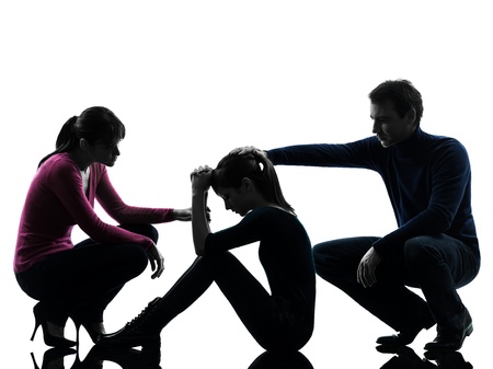 one caucasian family father mother consoling daughter  in silhouette studio isolated on white backgroundの写真素材