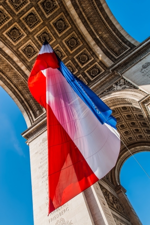 arc of triumph with the french flag floating in the city of Paris in franceの写真素材