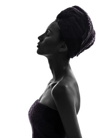 one beautiful asian young woman eyes closed portrait wrapped towel in silhouette studio isolated on white backgroundの写真素材