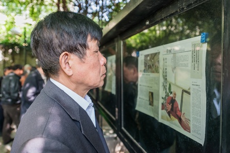 Shanghai, China - April 7, 2013  one man reading newspaper in fuxing park at the city of Shanghai in China on april 7th, 2013のeditorial素材