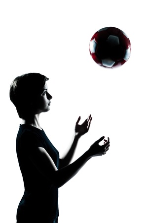 one caucasian young teenager silhouette girl tossing soccer football portrait in studio cut out isolated on white backgroundの写真素材
