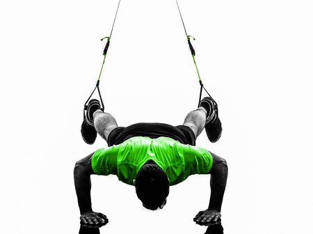 one caucasian man exercising   suspension training  trx   on white backgroundの写真素材