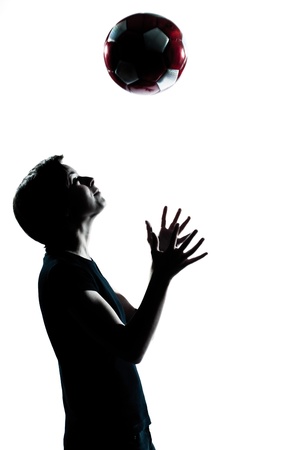 one caucasian young teenager silhouette boy girl tossing soccer football portrait in studio cut out isolated on white backgroundの写真素材