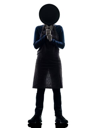one caucasian woman cooking  hiding behind frying pan  in silhouette studio isolated on white backgroundの写真素材