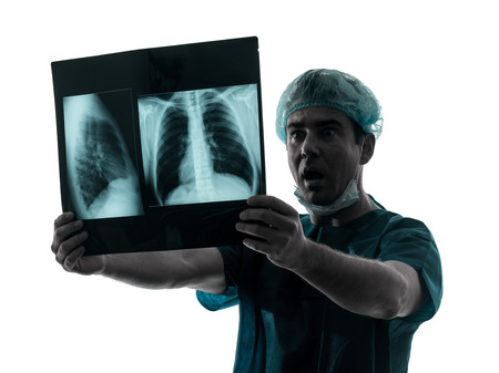 one caucasian man doctor surgeon radiologist medical surprised  examining lung torso  x-ray image...