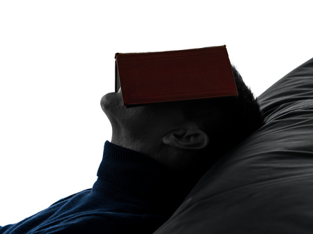 one caucasian man reading book portrait in silhouette studio isolated on white backgroundの写真素材
