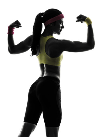 one  woman exercising fitness flexing muscles  rear view in silhouette  on white backgroundの写真素材