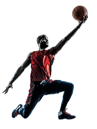 one african man basketball player jumping in silhouette isolated white backgroundの写真素材