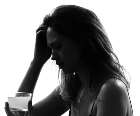 one woman taking effervescent medicine portrait silhouette studio on white backgroundの写真素材