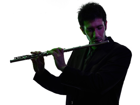one caucasian man  playing traverse flute player in studio silhouette isolated on white backgroundの写真素材