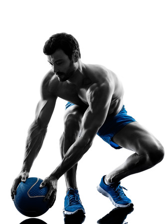 one caucasian man exercising fitness weights Medicine Ball exercises in studio silhouette isolated on white backgroundの写真素材