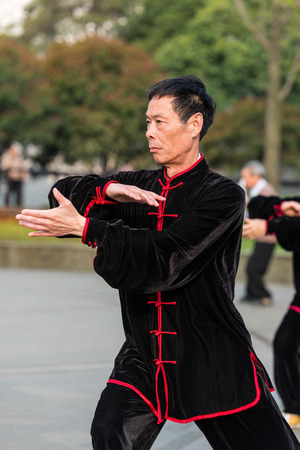 Shanghai, China - April 7, 2013: one man exercising tai chi with traditional costume in gucheng park in the city of Shanghai in China on april 7th, 2013のeditorial素材