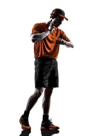 one young man runner jogger taking heartbeat pulse in silhouette isolated on white backgroundの写真素材