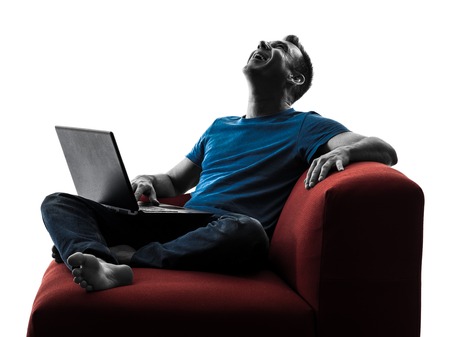 one caucasian man Laughing computer computing laptop in silhouette isolated on white backgroundの写真素材
