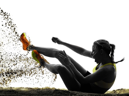one woman praticing Long Jump silhouette in studio silhouette isolated on white backgroundの写真素材