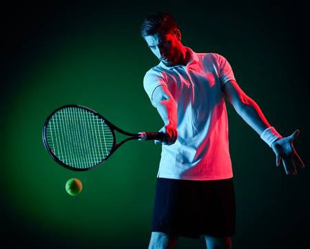 one caucasian tennis player man studio isolated on black backgroundの写真素材