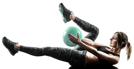 one caucasian woman exercising pilates fitness soft ball exercises isolated  silhouette on white backgroundの写真素材